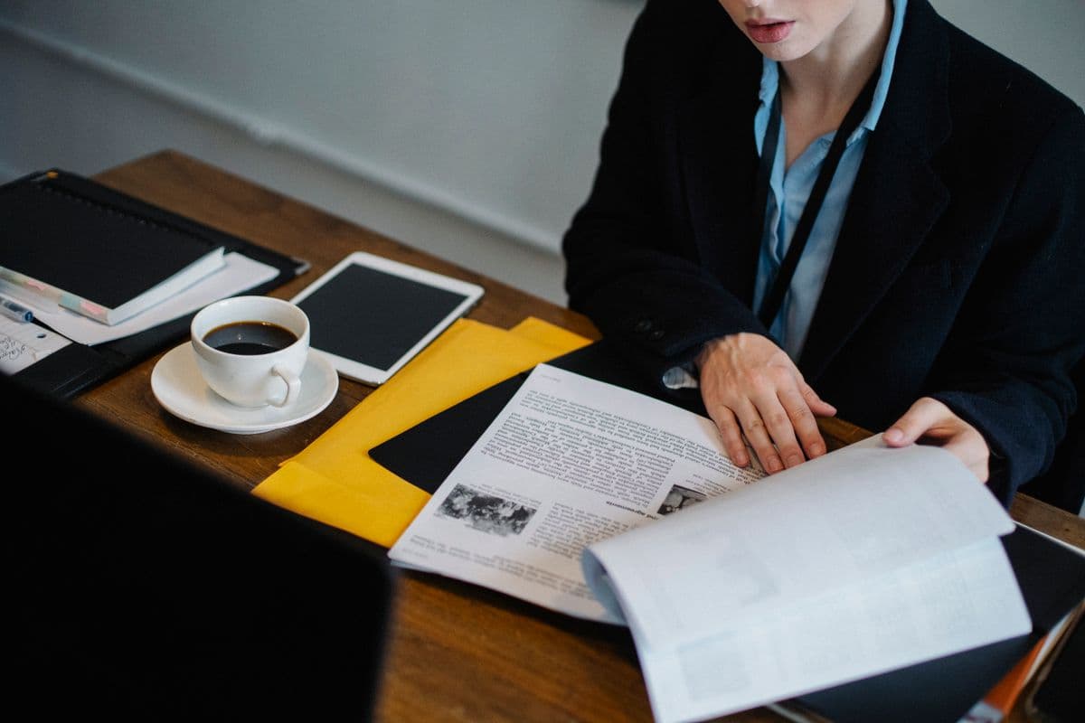 Business professional reviewing documents and reports at a desk, representing the approval review process.